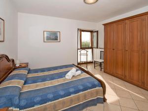 バルドリーノにあるApartment Ca' Bottrigo-2 by Interhomeのベッドルーム1室(ベッド1台付)、木製キャビネットが備わります。