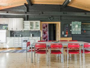a kitchen with a table and red chairs at Holiday Home Aamunkoi by Interhome in Pyhäsalmi