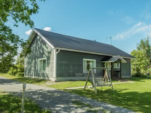 a house with a playground in front of it at Holiday Home Aamunkoi by Interhome in Pyhäsalmi