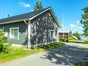 a gray house with a driveway in front of it at Holiday Home Aamunkoi by Interhome in Pyhäsalmi
