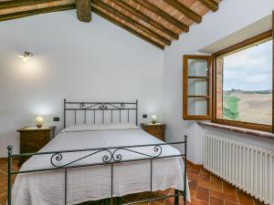 Schlafzimmer mit einem Bett und einem Fenster in der Unterkunft Holiday Home Villa Caggio-4 by Interhome in Volterra