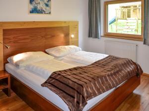 a bedroom with a large bed with a wooden headboard at Apartment Simon-2 by Interhome in Kappl