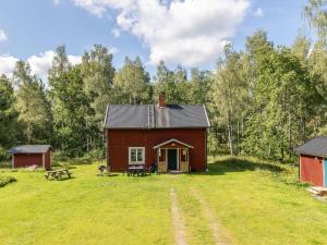 eine rote Scheune mitten auf einem Feld in der Unterkunft Chalet Mjöshult - SND157 by Interhome in Hjorted