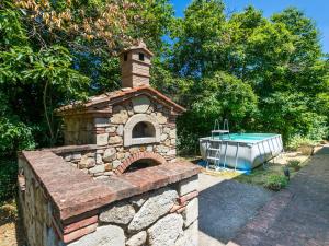 ロッカストラーダにあるHoliday Home Casale Fonte by Interhomeの庭にプール付きのレンガ造りのオーブン