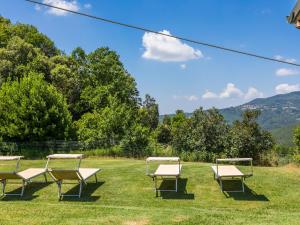 un grupo de bancos sentados en el césped en Holiday Home Casale Fonte by Interhome, en Roccastrada