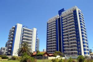 dos edificios altos en una ciudad con una casa en Apartamento Punta del Este Arenas, en Punta del Este