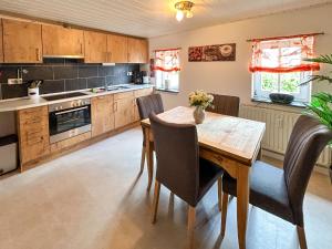a kitchen with a wooden table and chairs at Apartment Marie by Interhome in Großschönau