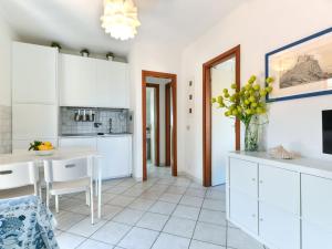 a kitchen with white cabinets and a table and chairs at Apartment Altaluna-6 by Interhome in Nisporto +21 photos