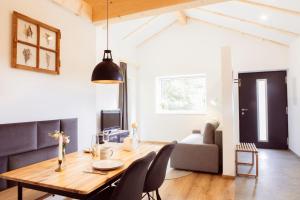 a dining room and living room with a wooden table and chairs at BachBett - modernes Gästehaus im Salzkammergut in Bad Ischl