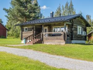 a log cabin with a porch and a gravel road at Holiday Home Aamunkoin rantatupa by Interhome in Pyhäsalmi