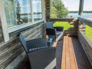 two chairs on a porch with a view of the water at Holiday Home Aamunkoin rantatupa by Interhome in Pyhäsalmi