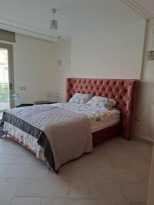 1 cama grande con cabecero rojo en un dormitorio en Couzi Haus Marina, en Agadir