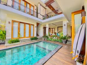 an indoor swimming pool in a house with a balcony at Mandox Villa Bali in Ungasan