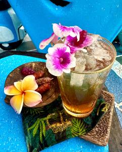un bicchiere di tè con fiori e frutta su un tavolo di ณ พรศุภะ เซรามิคคาเฟ่ 