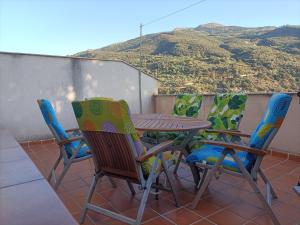 una mesa y sillas en un balcón con una montaña en Mirador del Duque, en Güéjar-Sierra