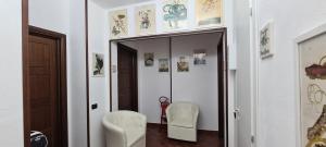 a hallway with two white chairs and a mirror at IL BORGO DEL BENESSERE in Rocca Imperiale +77 photos