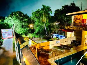 a balcony with chairs and a swimming pool at night at St CLAIRE'S GREEN Negombo Hotel & Hostels in Negombo