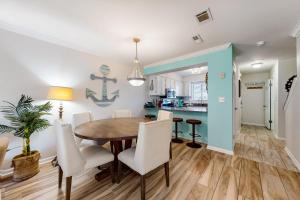 a dining room and kitchen with a wooden table and chairs at Portside Resort E2 in Panama City Beach