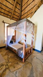 a bedroom with a bed with a mosquito net at Africa Safari Lake Natron in Mtowabaga