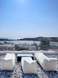 two white couches and a table and a view of the water at Blue Bay Vouliagmeni Luxury Apartment in Athens