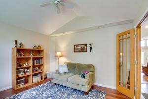 a living room with a chair and a book shelf at White Swan Lake Home with Decks and Private Beach! in Bigfork