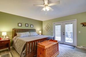 a bedroom with a bed and a ceiling fan at White Swan Lake Home with Decks and Private Beach! in Bigfork