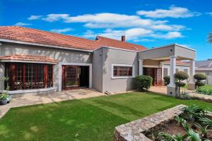 a house with a green lawn in front of it at Rose Road Manor - Houghton Johannesburg in Johannesburg