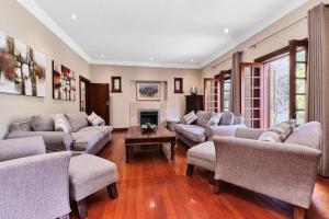 a living room with couches and a fireplace at Rose Road Manor - Houghton Johannesburg in Johannesburg