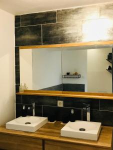 a bathroom with two white sinks and a mirror at L'Aparenthese - Aux portes de Fontainebleau in Voulx +25 photos