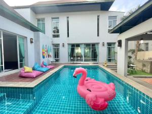 basen z dwoma dmuchanymi flamingami przed domem w obiekcie Pattaya private Jacuzzi Pool Villa Nearby BEACH w mieście Jomtien Beach