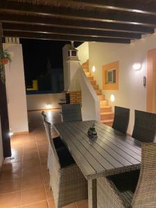 a dining room with a wooden table and chairs at Gomeira Terrace in Cabanas de Tavira
