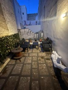 un patio avec des chaises et des tables dans un bâtiment dans l'établissement LA CASETTA 2.0, à Ostuni