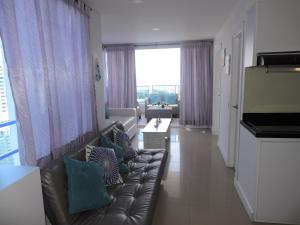 a living room with a leather couch with pillows at Apartamento Mares de Cartagena in Cartagena de Indias