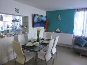 a dining room with a table and chairs and a tv at Apartamento Mares de Cartagena in Cartagena de Indias