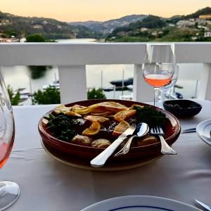 un piatto di cibo su un tavolo con bicchieri di vino di Stone House Entre os Rios a Entre-os-Rios - Penafiel