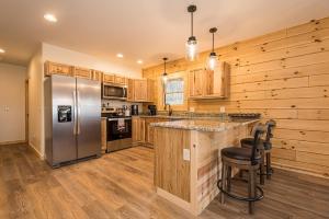 eine Küche mit Holzschränken und einem Kühlschrank aus Edelstahl in der Unterkunft Johns Place in McHenry