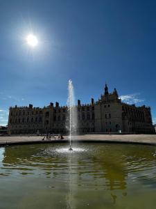a fountain in front of a large building at Sweet Abreuvoir in Saint-Germain-en-Laye