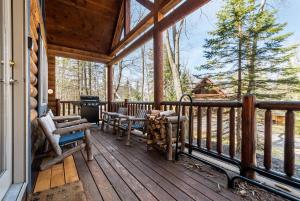 a porch of a cabin with two chairs and a table at Evergreen in Oakland