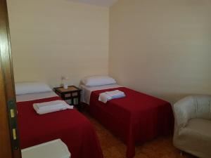 two beds in a room with a couch and a chair at Al comune in Atri