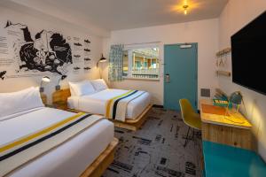 a hotel room with two beds and a tv at The Wren in Missoula