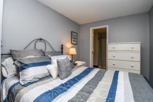 a bedroom with a bed with a blue and white comforter at Villages of Wisp 08 Winding Way in McHenry