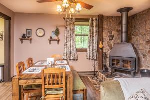 a dining room with a table and a wood stove at Woodside Retreat in McHenry