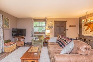 a living room with a couch and a tv at Woodside Retreat in McHenry