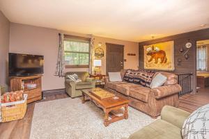 a living room with a couch and a tv at Woodside Retreat in McHenry