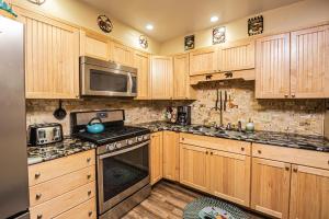 a kitchen with wooden cabinets and stainless steel appliances at Woodside Retreat in McHenry +23 photos