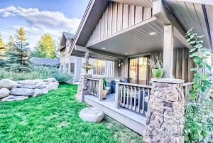 a house with a porch and a yard with green grass at Villa BG in Steamboat Springs