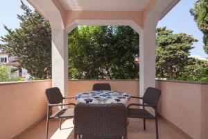 un patio con mesa y sillas en un porche en Apartment Juliette, en Zadar