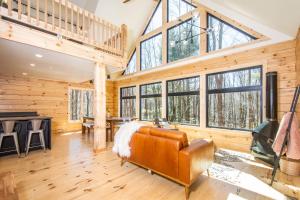 a large living room with wooden walls and large windows at Camp Wondermore in Swanton +42 photos