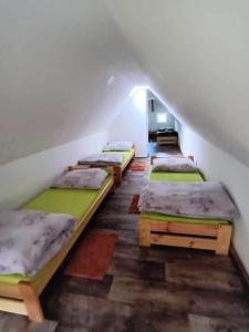 a group of beds in a room with a attic at Chata u Křupalů in Polevsko