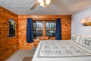 Schlafzimmer mit einem Bett und einem Fenster mit blauen Vorhängen in der Unterkunft Sunset Ridge in McHenry